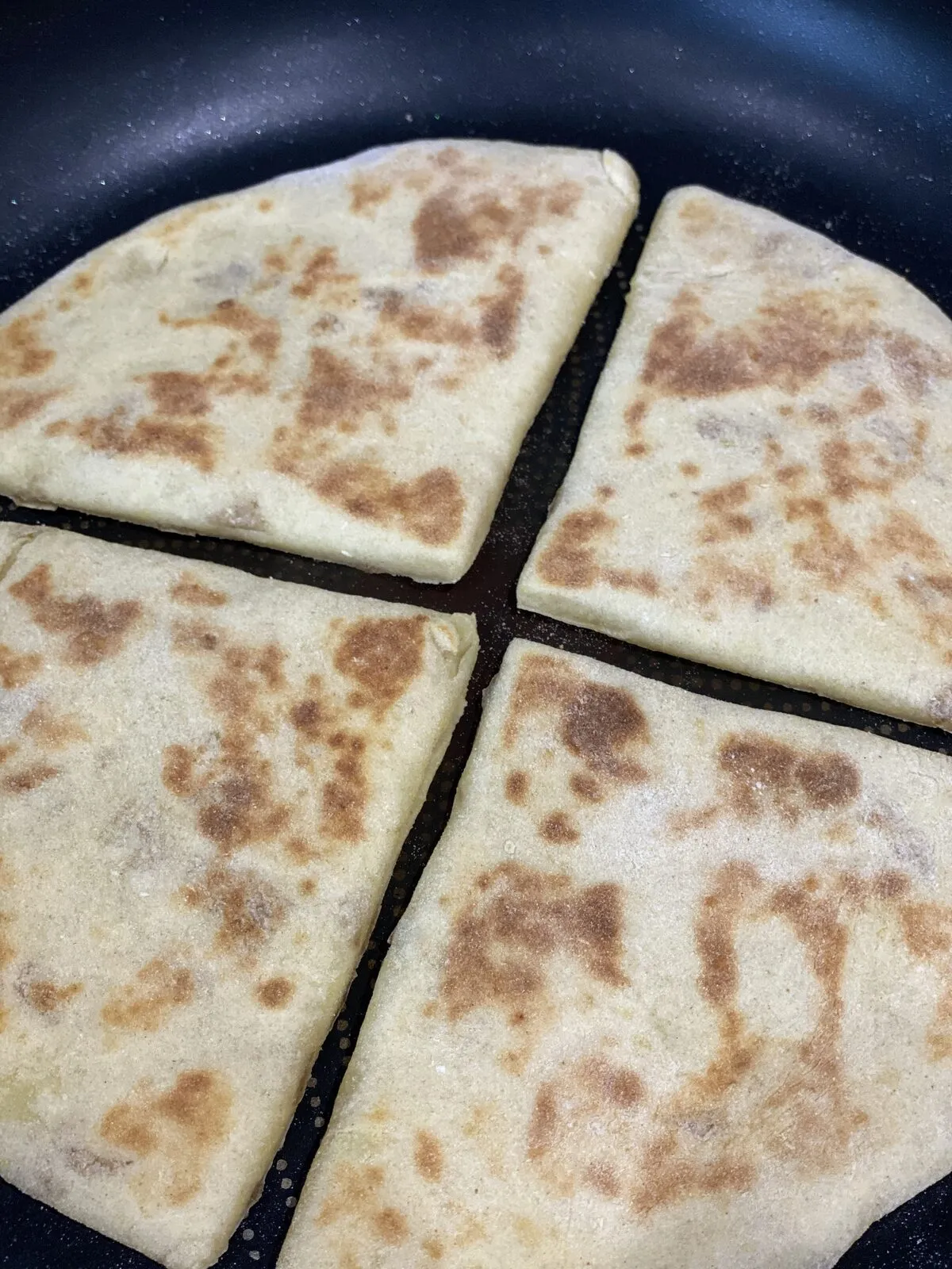 Tattie scones cooking in a pan on the hob